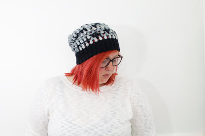 lightweight puff stitch beanie in variegated shades of black and gray on model with neon red hair.