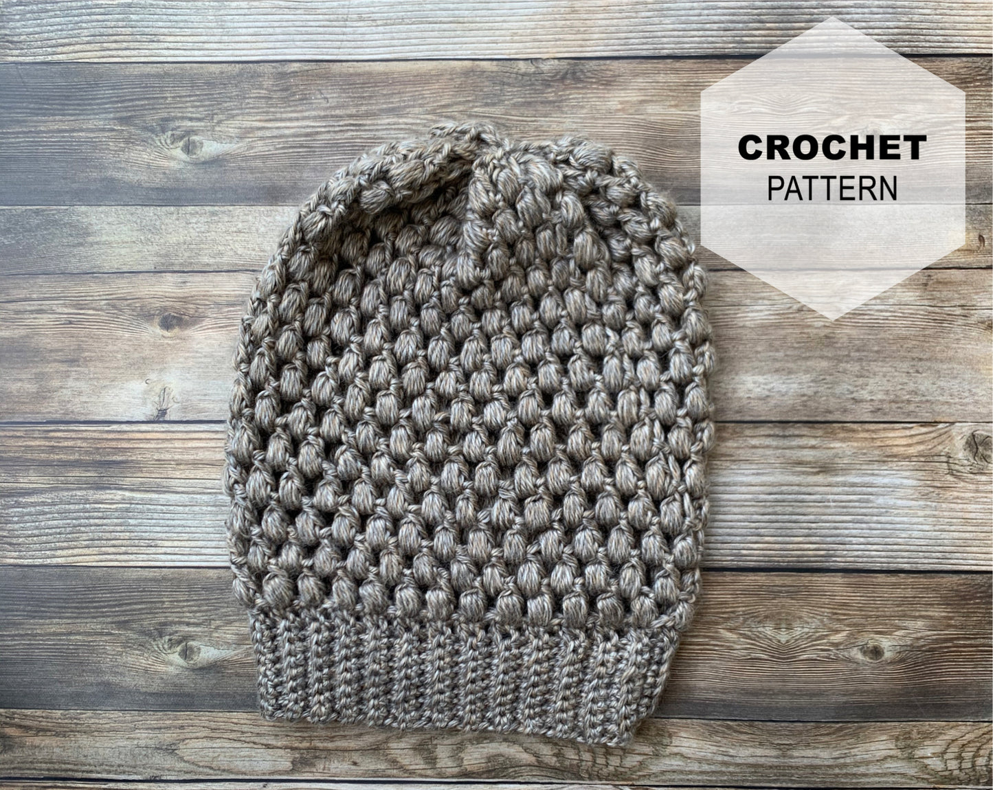 Puff stitch beanie in tan on wood background with logo describing the listing is for a crochet pattern of the beanie